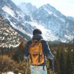 men s blue leather jacket and brown backpack