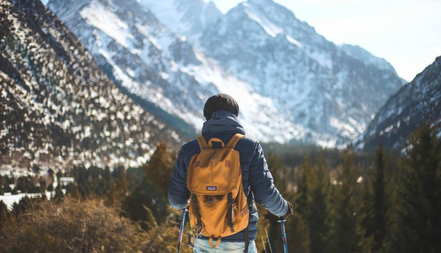 men s blue leather jacket and brown backpack